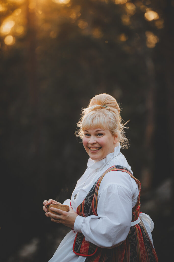 Kreetta, local singer-performer wearing Finnish national dress in a forest of Rovaniemi.