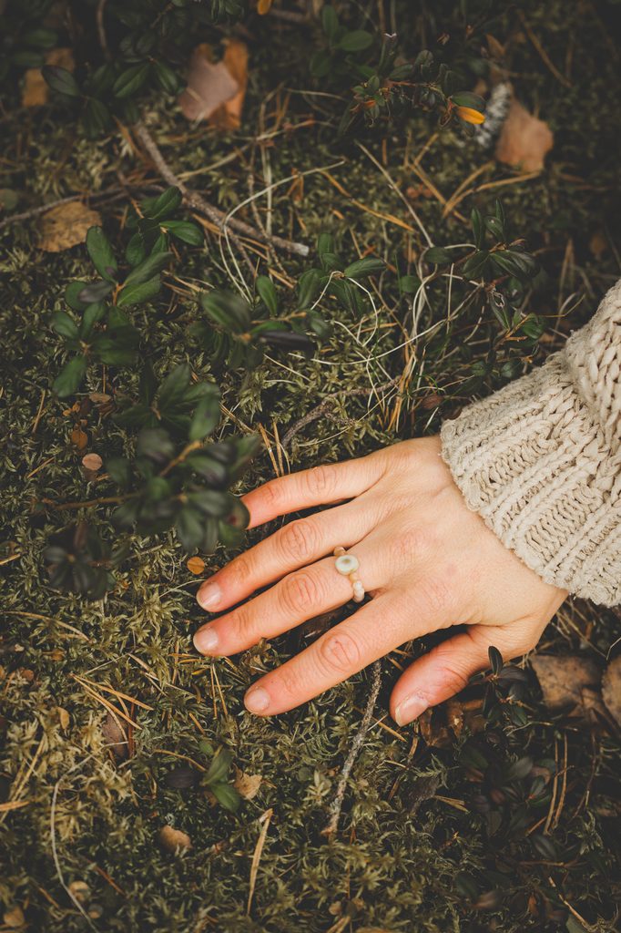 A hand touching the earth, capturing a quiet moment of connection with nature in Finland.